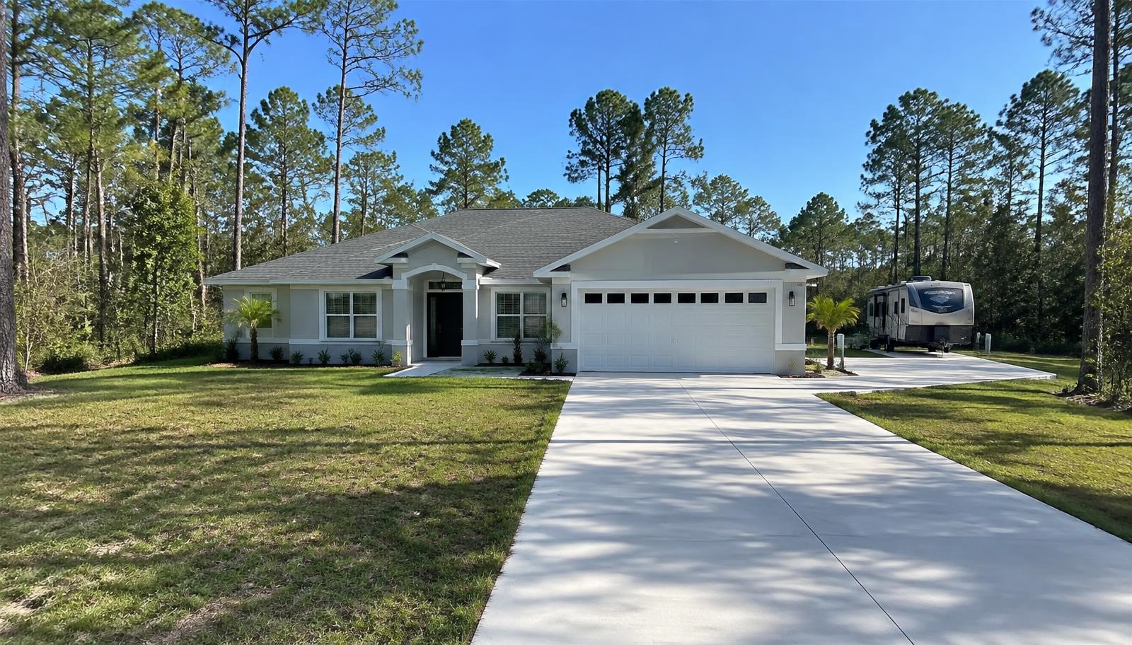 Long new concrete driveway with side RV pad at a wooded home in Citrus Springs, FL